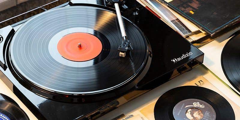 De Audiozio platenspeler in de kleur zwart, met een vinylplaat er naast. 