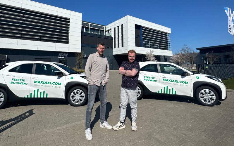MaxiAxi medewerkers die poseren voor de nieuwe MaxiAxi bedrijfsauto's