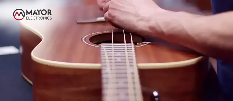 Persona cambiando las cuerdas de una guitarra