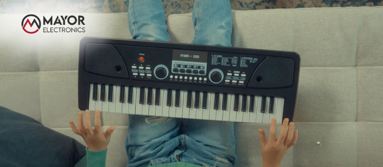 Un niño tocando un teclado infantil en el sofá