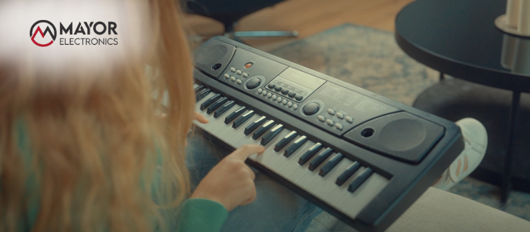 Una niña tocando un teclado infantil Rhapsody de 49 teclas