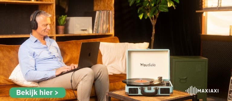 Een man die met een koptelefoon naar vinyl luisteren op de Audizio RP316 platenspeler