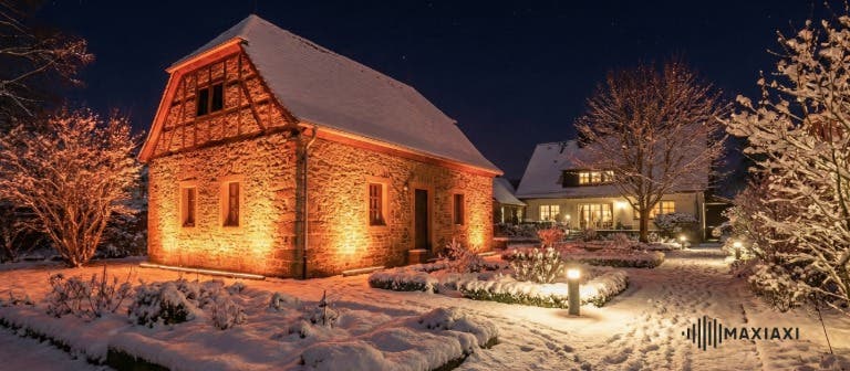 wall wash in een tuin met sneeuw die de gevel van een schuur verlicht