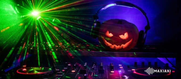 DJ-set met een pompoen met koptelefoon en groene lasereffecten tijdens een Halloweenfeest.
