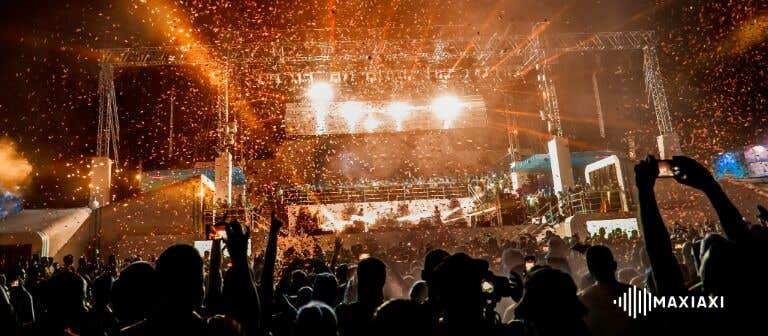 Großes Open-Air-Festival bei Nacht mit Konfetti und heller Bühnenbeleuchtung – jubelndes Publikum vor der Hauptbühne.