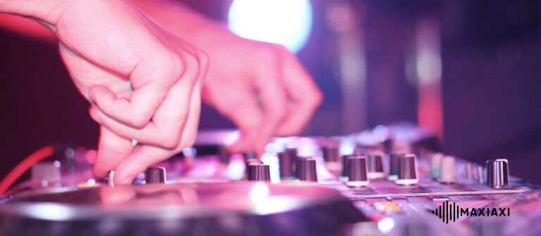 Nahaufnahme von Händen, die an einem DJ-Mischpult Regler und Jogwheels bedienen.