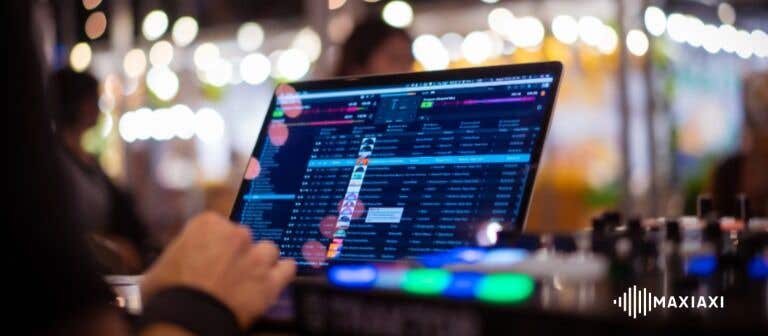 DJ arbeitet mit Laptop und DJ-Software an einem Controller während eines Events.