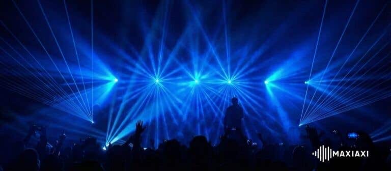 Bühnenaufnahme mit blauem Laserlicht und Silhouetten des Publikums – beeindruckende Lichtshow während eines Live-Auftritts