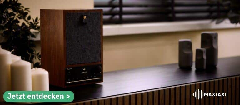 Vertikales Audizio Canzo DAB-Radio auf einem Sideboard – modernes Digitalradio mit Stofffront und Holzgehäuse