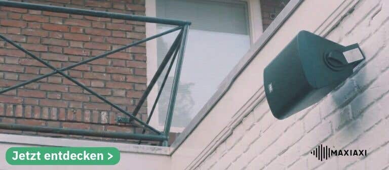 Außenlautsprecher an einer Hauswand unter een balkon montiert