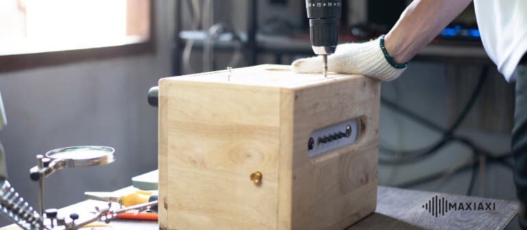 De behuizing van een DIY speaker in elkaar schroeven